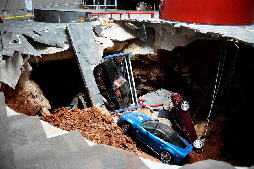 FILE - In this Feb. 12, 2014, file photo, cars lie in a sinkhole that opened up at the Skydome showroom in the National Corvette Museum in Bowling Green, Ky. Workers arrived at the museum on Monday, Nov. 10, 2014 to start plugging the hole that swallowed eight prized sports cars. Museum officials say security camera footage showing the floor’s collapse has been viewed nearly 8.4 million times on YouTube. (AP Photo/Michael Noble Jr., File)