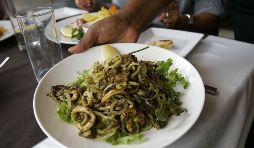 A waitress brings a seafood salad with grilled octopus, calamari and prawns. (AP Photo/Beatrice Larco)