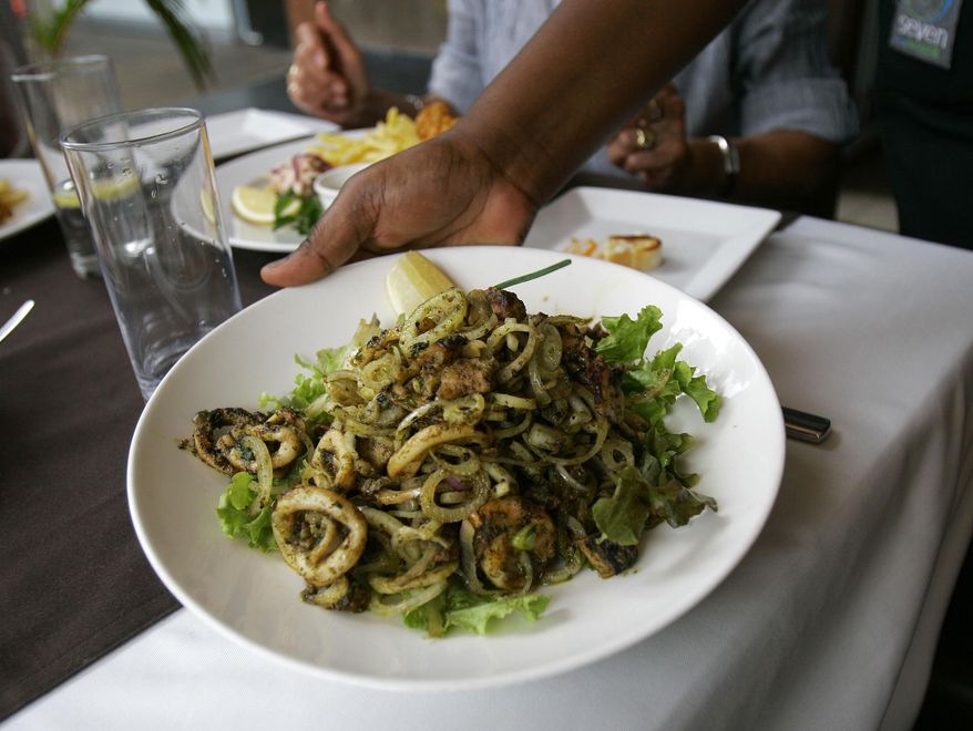 A waitress brings a seafood salad with grilled octopus, calamari and prawns. (AP Photo/Beatrice Larco)