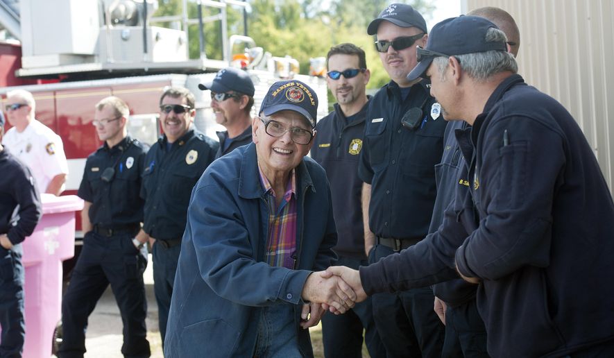 Marine Corps veteran and retired Tyler firefighter Bill Lynn shakes hands with current Tyler Fire Department members including apparatus technician Brad Smith, pictured at right, Monday, Nov. 10, 2014 during the Tyler Fire Department's annual Veterans Day Cookout for city employees and veterans held at Tyler Fire Department Training Complex, 701 Fairpark Drive. The event included a barbeque and program to honor veteran service. (AP Photo/Tyler Morning Telegraph, Sarah A. Miller)