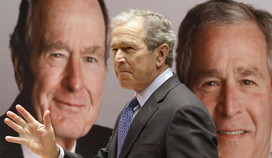 Former President George W. Bush passes by a portrait of himself and his father former President George H.W. Bush as he takes the stage to discuss his new book, &quot;41: A Portrait of My Father&quot; at the his father&#39;s presidential library Tuesday, Nov. 11, 2014, in College Station, Texas. (Associated Press) ** FILE **