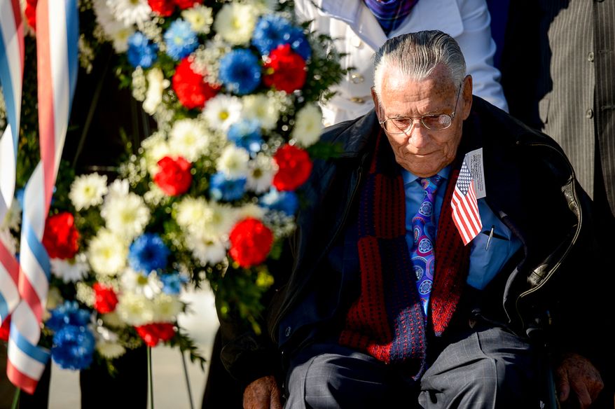 Retired Air Force Staff Sgt. Frank Rigo of Phoenix, Ariz., sits in his wheelchair in front of a memorial wreath he helped play at the World War II Memorial during a Veterans Day commemoration on the morning of Veterans Day, Washington, D.C., Tuesday, November 11, 2014. The event was hosted by the Friends of the World War II Memorial, the National Park Service and the Military District of Washington host. (Andrew Harnik/The Washington Times)