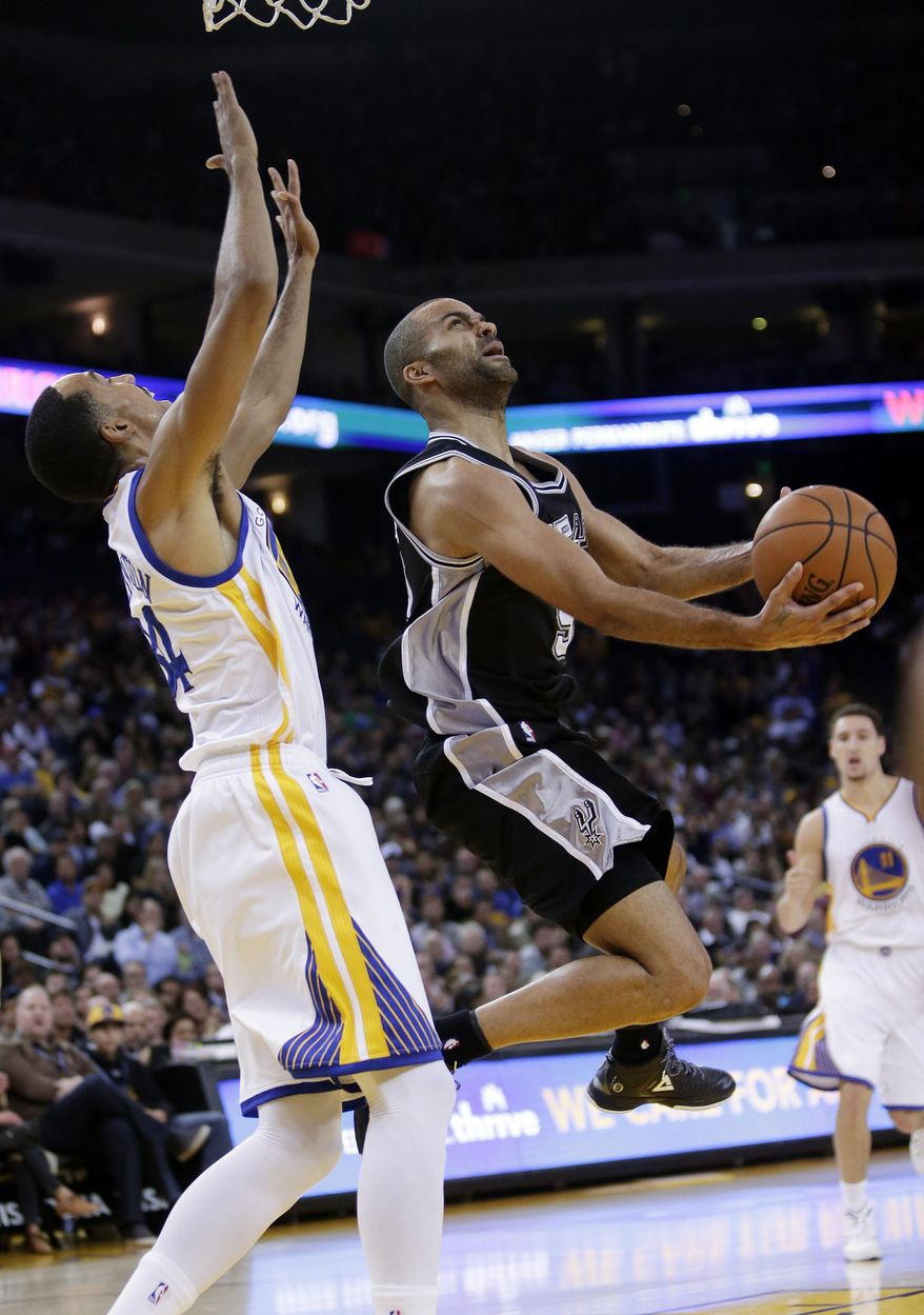 San Antonio Spurs' Tony Parker, right, looks to shoot against Golden State Warriors' Shaun Livingston during the first half of an NBA basketball game Tuesday, Nov. 11, 2014, in Oakland, Calif. (AP Photo/Marcio Jose Sanchez)