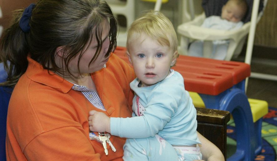 Tasha Burns holds her daughter, Heaven, 13 months, as her son, Brian, 4 months, sleeps at rear in a Salvation Army homeless shelter in Oklahoma City on April 3, 2007. The Burns family has been homeless since Hurricane Katrina hit Florida in August of 2005. (Associated Press) **FILE**