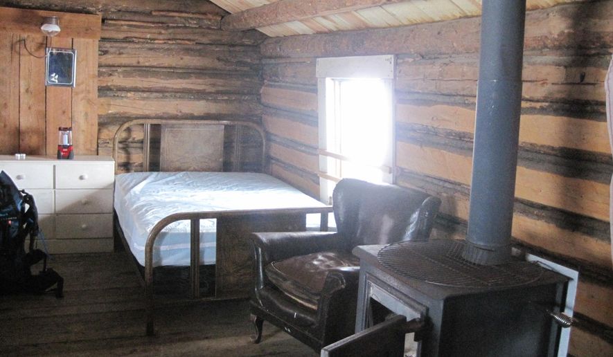 ADVANCE FOR USE ON MONDAY, NOV. 17 - In this photo taken on Feb. 23, 2014, the McDonald Cabin is furnished with two beds, a couple chairs, a table, a wood stove and a propane stove for cooking in the ghost town of Garnet, Mont. The town is accessible by car in the summer, but in the winter visitors must snowshoe, ski or snowmobile to reach it. (AP Photo/Great Falls Tribune, Erin Madison)