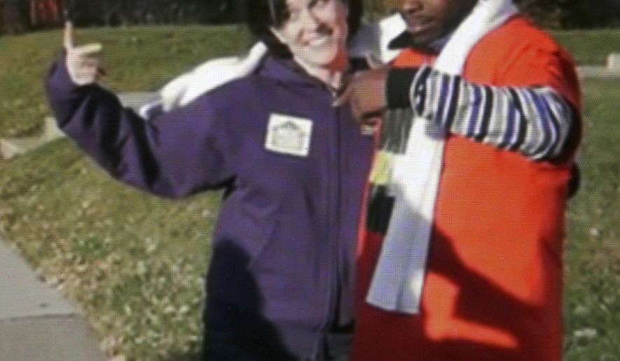 FILE - In this file image made from a video released by Neighborhoods Organizing for Change, Minneapolis Mayor Betsy Hodges and Neighborhoods Organizing for Change employee Navell Gordon gesture while they knock on doors to get out the vote in north Minneapolis last Saturday, Nov. 1, 2014. A kerfuffle over whether Minneapolis’ mayor was flashing a gang sign when she posed with a man while door-knocking before the election has turned into a mini-bonanza for the small nonprofit that organized the get-out-the-vote event. (AP Photo/Neighborhoods Organizing for Change, File)