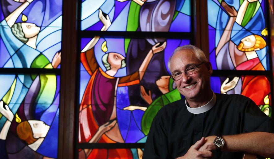 This Oct. 30, 2014 photo shows the Reverend Clay Lein, the new rector at St. John&#39;s Episcopal Church in Houston.   Seated in a study at Houston&#39;s St. John the Divine Episcopal Church, where on Sunday he will deliver his first sermon as the 75-year-old congregation&#39;s new rector, Lein spun his tale of how a scoffing man of science was transformed through the agency of sports into a staunch believer.  (AP Photo/Houston Chronicle, Karen Warren)