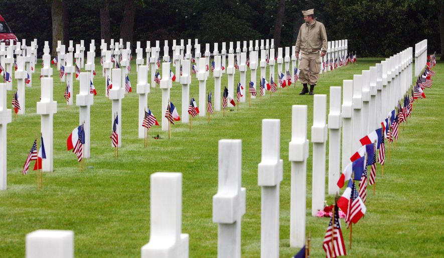 An unidentified visitor wearing a U.S. military nurse uniform walks past graves at the American cemetery, in Colleville-sur-Mer, western France, on June 6, 2007, marking the 63rd anniversary of the D-Day landings in Normandy. (Associated Press) **FILE**