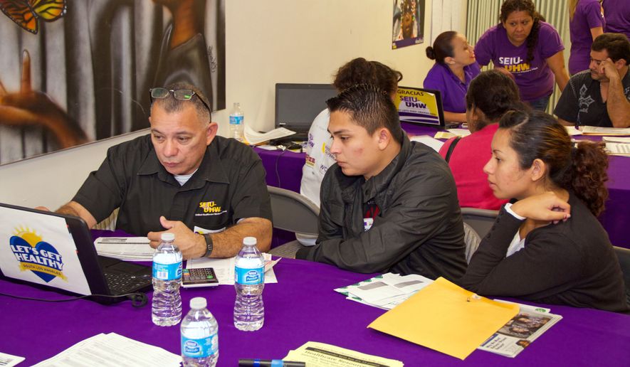 This photo provided by the Service Employees International Union show a couple reviewing health care plans at an Affordable Care Act enrollment event sponsored by SEIU-United Healthcare Workers West and Community Coalition, in Los Angeles Saturday, Nov. 15, 2014. (AP Photo/SEIU, Michael Chavez) ** FILE **