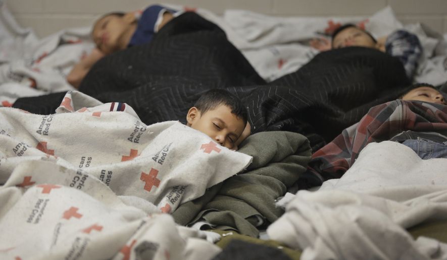 Detainees sleep in a holding cell at a U.S. Customs and Border Protection processing facility in Brownsville, Texas. (Associated Press) ** FILE **