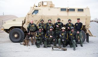 In this undated handout photo provided by the Lancaster County Sheriff&#39;s Office, the Lancaster County Sheriff&#39;s Office Tactical Response Unit poses in front of a MRAP (Mine-Resistant Ambush Protected) Armored Vehicle, a surplus military vehicle that came through a federal program, in Lincoln, Neb. (AP Photo/Lancaster County Sheriff&#39;s Office)