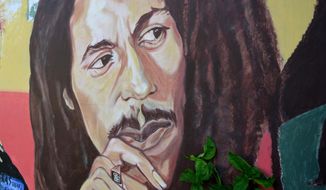 In this Feb. 6, 2013, file photo, a mural depicting reggae music icon Bob Marley decorates a wall in the yard of Marley&#39;s Kingston home in Jamaica. A U.S. private equity firm announced Tuesday, Nov. 18, 2014 it has joined the family of late reggae star Bob Marley in hopes of building what it touts as the &amp;quot;world&#39;s first global cannabis brand.&amp;quot; (AP Photo/ David McFadden, File)
