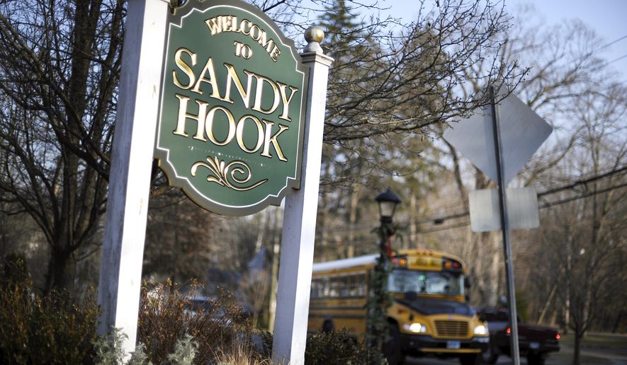 FILE - In this Dec. 4, 2013 file photo, a school bus drives past a sign reading Welcome to Sandy Hook, in Newtown, Conn., where 26 people were killed by a gunman inside Sandy Hook Elementary School. A new play about the massacre at the Sandy Hook Elementary School will have a benefit reading in December in New York City to commemorate the second anniversary of the tragedy. Eric Ulloa’s “26 Pebbles,” which was adapted from transcripts of interviews with people touched by the shootings, will have a staged reading Dec. 15 at the Culture Project’s The Lynn Redgrave Theater. The director will be Igor Goldin and prices range from $50-$150. (AP Photo/Jessica Hill, File)