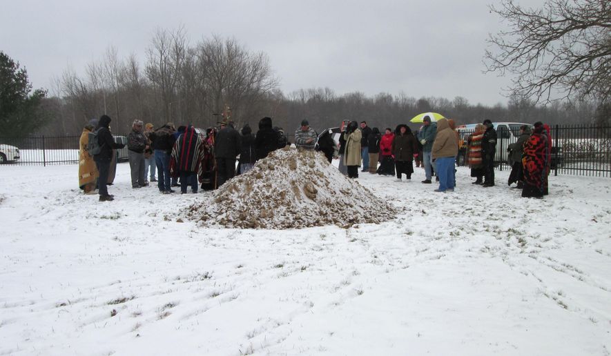 People gather at the Saginaw Chippewa Indian Tribe&#39;s Nibokaan Cemetery to repatriate the remains of ancestors removed from the University of Michigan&#39;s Museum of Anthropological Archaeology, Wednesday, Nov. 19, 2014 in Chippewa Township, Mich. The tribe says that from 1923 to 1935, human remains representing at least 94 individuals were removed from a site in Lapeer County north of Imlay City. They were collected by an archaeologist and were donated to the museum along with funerary objects. (AP Photo/The Morning Sun, Randi Shaffer)