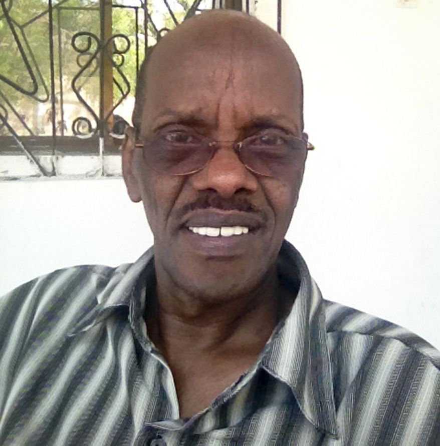 This photo taken Sunday, Sept. 29, 2013 and provided by the family of Abdullahi Ali Anshur, 60, shows the Somali-American from Minnesota at his office in Mogadishu, Somalia. Gunmen shot and killed Abdullahi Ali Anshur, an engineer from Minnesota who had left a well-paying job in the U.S to help the fledgling Mogadishu city government with urban planning and drainage systems, a Somali official and relative said Wednesday, Nov. 19, 2014. (AP Photo/Family of Abdullahi Ali Anshur)