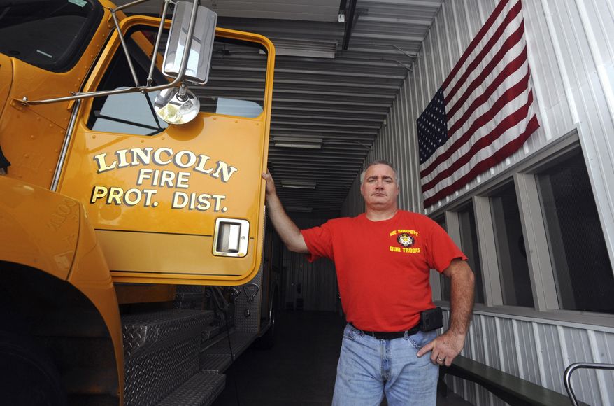 In this Oct. 23, 2014 photo, Rob Ratliff, the Fire Chief at Lincoln Fire Protection District Station No. 2, poses for a photo at the station in small town of Lerna, Ill. Ratliff knows a few things about the small town he's spent most of his life in, beginning in 1979. (AP Photo/Journal Gazette, Kevin Kilhoffer)