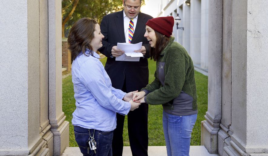 Kayla Bennett, left, and Kristin Anderson exchange wedding vows as Minister Tobin Williamson officiates the first same-sex couple wedding ceremony in South Carolina Wednesday, Nov. 19, 2014 in front of the Charleston County Judicial Center in Charleston, S.C. Couples began filing in to pickup their marriage licenses after Probate Court Judge Irvin Condon began issuing them Wednesday morning. (AP Photo/The Post And Courier, Paul Zoeller)