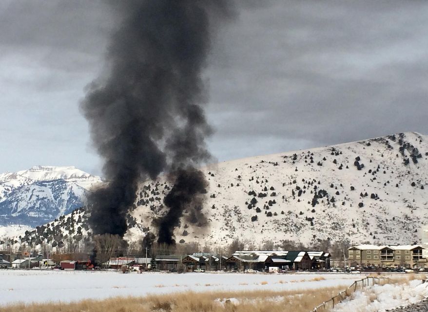 Columns of smoke rise above Jackson, Wyoming, following an explosion at a propane dealer Thursday, Nov. 20, 2014. The blast forced the evacuation of several businesses and a small school in the vicinity but police and emergency officials say there were no immediate reports of injuries. (AP Photo/Marvin Arriola)