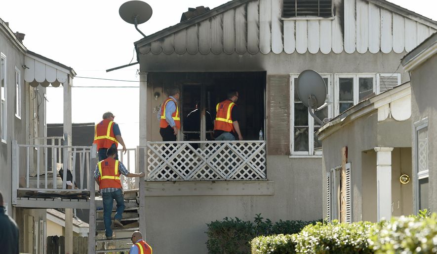Southern California Gas Company officials enter an apartment that caught fire killing two children ages 2 and 6 in San Bernardino, Calif., Thursday, Nov. 20, 2014. The children were killed early Thursday in the California apartment fire that broke out hours after their mother went to a hospital to give birth, authorities said. The children's father was critically injured in the blaze at the two-story duplex, fire Battalion Chief Michael Bilheimer said. (AP Photo/The Sun, John Valenzuela) MANDATORY CREDIT