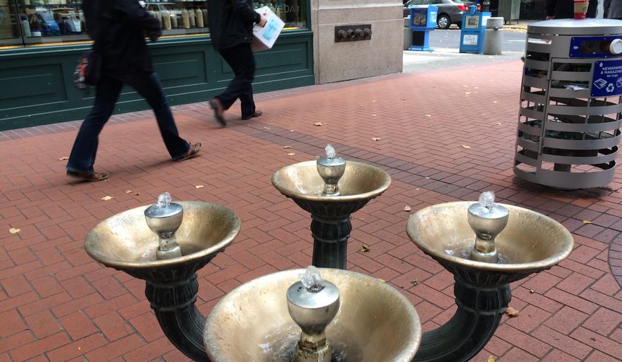 This Nov. 7, 2014 photo shows the first Benson Bubbler at the corner of Southwest Fifth and Washington in downtown Portland. Ore. Benson Bubblers are those brass, four-bowled water fountains that you can see scattered through the downtown core. Benson Bubblers go back to 1912, when Simon Benson donated $10,000 to the city (roughly $240,000 in today's money) to purchase and install 20 of the fountains. Engineers with the Water Bureau have struggled for decades with the question of how to balance the city's penchant for conservation with the sheer beauty of the fountains. (AP Photo/The Oregonian, John Killen) MAGS OUT; TV OUT; NO LOCAL INTERNET; THE MERCURY OUT; WILLAMETTE WEEK OUT; PAMPLIN MEDIA GROUP OUT