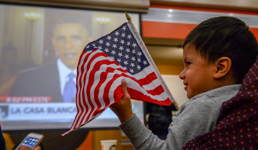 American citizen Abraham Meza-Campos, 2, of Silver Spring, Md,. holds an American flag as he watches President Obama's speech on his plans for protections for undocumented immigrants at a watch party held at CASA de Maryland's multicultural center in Hyattsville, Md., on Thursday, November 20, 2014. (Andrew Harnik/The Washington Times)