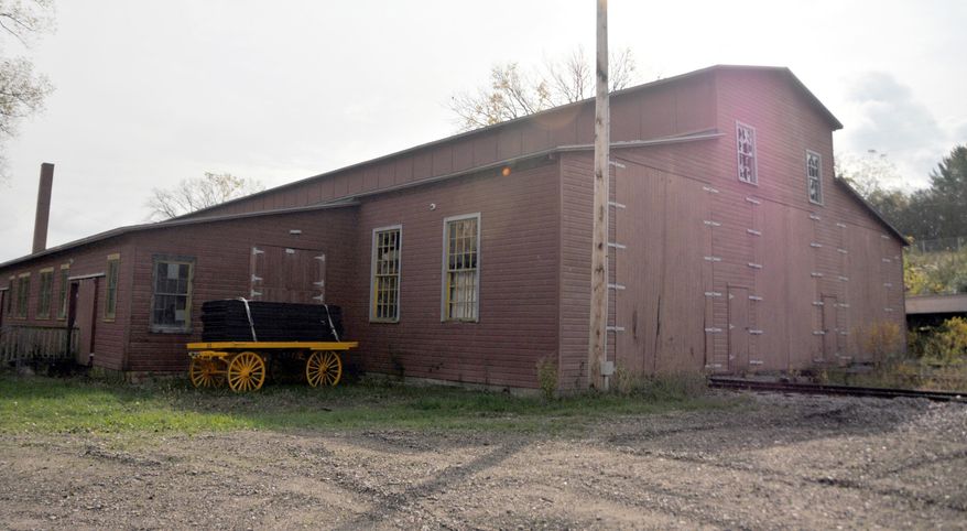 In this Oct. 17, 2013 photo, new doors were installed as part of the initial phases of restoration of the Ringling train shed along the Baraboo Riveras in Baraboo, Wis. A $1 million renovation of the unique building which housed train cars that took the "greatest show on Earth" across the country, is complete. The Circus World Museum says it's the longest wooden railroad structure in America. (AP Photo/Baraboo News Republic, Ben Bromley )