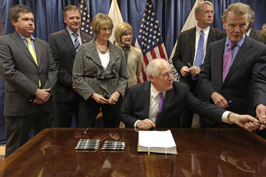 FILE - in this Dec. 5, 2013 file photo, Illinois Gov. Pat Quinn hands off a pen during the signing of the pension overhaul legislation bill in Chicago. A Sangamon County judge's ruling Friday Nov. 21, 2014 on the constitutionality of the landmark Illinois pension overhaul could determine whether the matter is ultimately decided by the state Supreme Court. Looking on from left are: state Rep. Mike Zalewski, D-Riverside; Sen. Bill Brady, R-Bloomington; Senate GOP leader Sen. Christine Radogno; Rep. Darlene Senger, R-Naperville; Rep. Jim Durkin, R-Western Springs and House Speaker Michael Madigan. (AP Photo/M. Spencer Green, File)