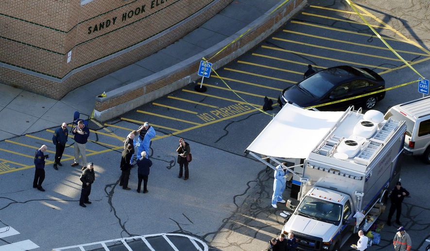 This Dec. 14, 2012, aerial file photo shows officials standing outside of Sandy Hook Elementary School in Newtown, Conn. (AP Photo/Julio Cortez, file) ** FILE **