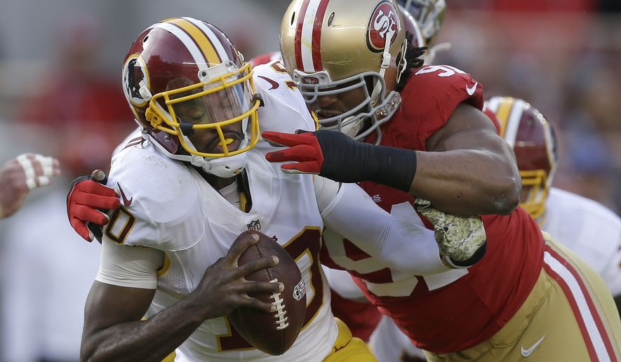 Washington Redskins quarterback Robert Griffin III, left, is sacked by San Francisco 49ers defensive tackle Ray McDonald during the first quarter of an NFL football game in Santa Clara, Calif., Sunday, Nov. 23, 2014. (AP Photo/Ben Margot)