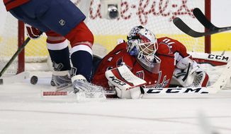 The wining goal by Buffalo Sabres center Torrey Mitchell gets past Washington Capitals goalie Braden Holtby (70) in the third period of an NHL hockey game, Saturday, Nov. 22, 2014, in Washington. The Sabres won 2-1. (AP Photo/Alex Brandon)