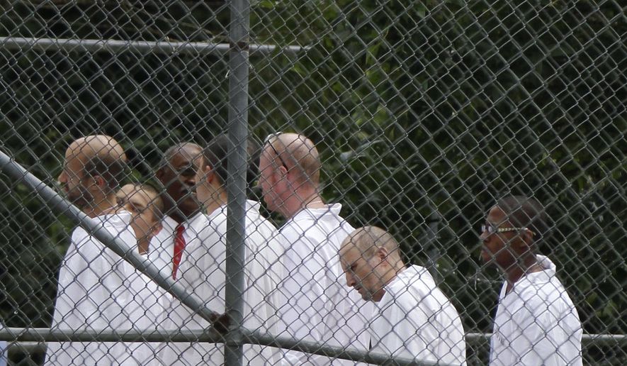 FILE - In this July 21, 2014, file photo, Arkansas Department of Correction inmates wait to enter an unused building near the Pulaski County Jail in Little Rock, Ark. A report issued to a state legislative committee Monday, Nov. 24, 2014, detailed alternatives to the expected proposal to build a 1,000-inmate prison to ease overcrowding of state inmates at county jails. (AP Photo/Danny Johnston, File)