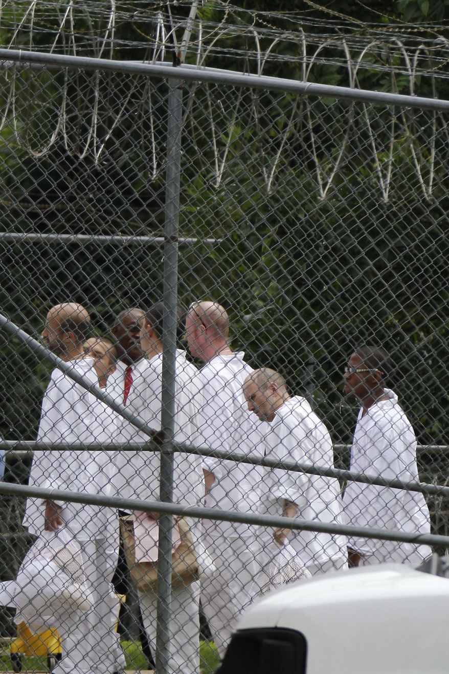 FILE - In this July 21, 2014, file photo, Arkansas Department of Correction inmates wait to enter an unused building near the Pulaski County Jail in Little Rock, Ark. A report issued to a state legislative committee Monday, Nov. 24, 2014, detailed alternatives to the expected proposal to build a 1,000-inmate prison to ease overcrowding of state inmates at county jails. (AP Photo/Danny Johnston, File)
