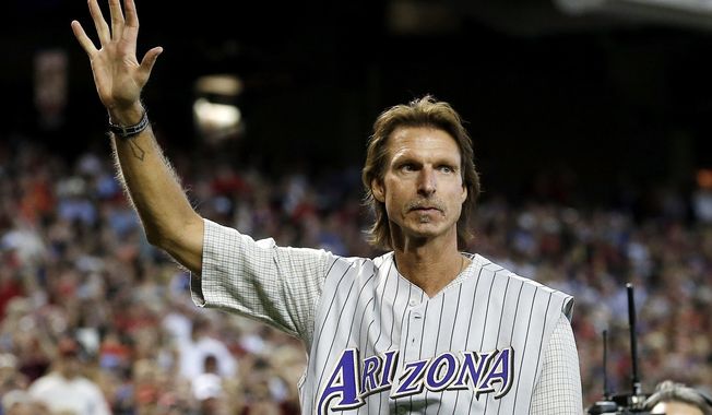 Former Arizona Diamondbacks pitcher Randy Johnson waves to the crowd during ceremonies commemorating the 10th anniversary of Johnson&#x27;s perfect game prior to a baseball game between the Diamondbacks and the Los Angeles Dodgers on Sunday, May 18, 2014, in Phoenix. (AP Photo/Ross D. Franklin)