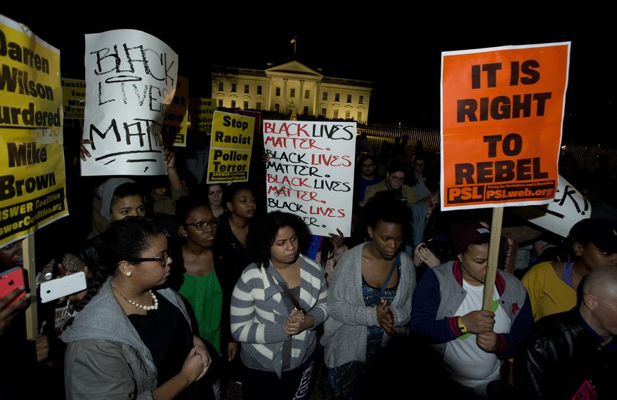Protestors carry signs and gather in front of the White House in Washington, Tuesday, Nov. 25, 2014, after the Ferguson grand jury decided not to indict police officer Darren Wilson in the shooting death of Michael Brown. (Associated Press)