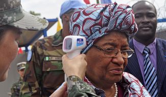 Liberian President Ellen Johnson Sirleaf, center,  temperature is taken by a Chinese soldier, left, before the opening of a new Ebola virus clinic sponsored by China, in Monrovia, Liberia, Tuesday, Nov. 25, 2014, Liberia got another 100 treatment beds in the fight against Ebola on Tuesday, as yet another Sierra Leonean doctor became infected with the disease sweeping West Africa. Liberian President Ellen Johnson Sirleaf toured the Ebola treatment center built by China, calling it “first-class.”(AP Photo/ Abbas Dulleh) **FILE**