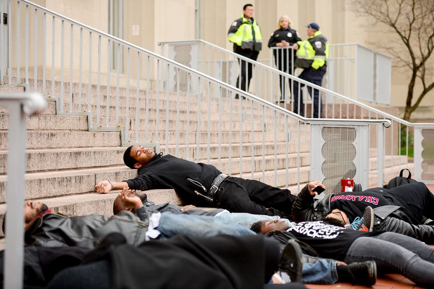 Members of the DC chapter of the Black Youth Project 100 (BYP100) participate in a "Die-In" on the steps of the Washington, D.C. Metropolitan Police Department headquarters at 300 Indiana Avenue, NW after a Grand Jury’s decision to not indict Ferguson police officer Darren Wilson in the killing of 18 year-old Michael Brown, Washington, D.C., Tuesday, November 25, 2014. The non-violent protest was part of a 28 hour long series of protests "aimed at bringing an end to the cycle of state sanction violence against local black communities carried out by the police." (Andrew Harnik/The Washington Times)