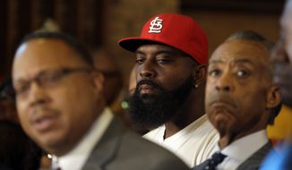 Michael Brown Sr., center, listens along side Rev. Al Sharpton, right, as Brown family attorney Anthony Gray, left, speaks during a news conference at Greater St. Mark Church Tuesday, Nov. 25, 2014, in St. Louis County, Mo. Rioting broke out Monday after a grand jury decided not to indict a white Ferguson police officer in the shooting death of the unarmed, black 18-year-old Michael Brown. (AP Photo/Jeff Roberson)