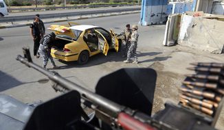 In this Saturday, Nov. 22, 2014, photo, Iraqi federal policemen search a car at a checkpoint in Baghdad, Iraq. The government is now trying to revamp security measures, moving away from reliance on ubiquitous concrete blast walls and police checkpoints. Instead, the plan is to beef up police intelligence units that have gone understaffed and underfunded since the fall of Saddam Hussein. (AP Photo/Karim Kadim)