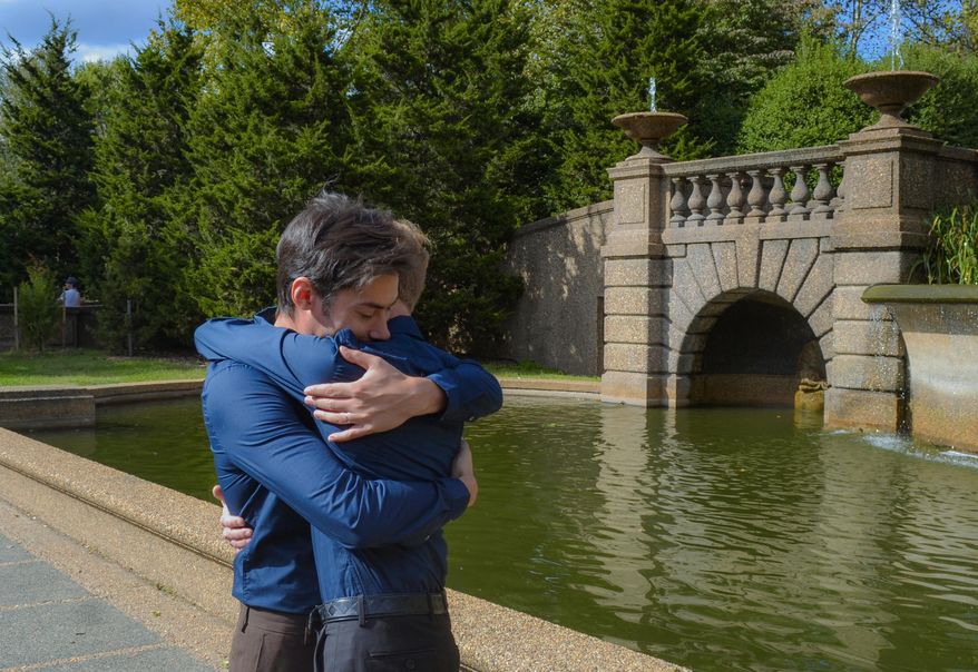 ADVANCE FOR USE SUNDAY, NOV. 30, 2014, AND THEREAFTER- In this Oct. 18, 2014, photo provided by Michael Knaapen, Andrew Nasonov hugs Igor Bazilevsky, left, after the couple was married at Meridian Hill Park in Washington. They both came to the U.S. from Russia in July, and are preparing to file an application seeking asylum in the U.S. The increase in the overall applications for asylum by Russians is due in part to the worsening anti-gay climate in Russia, according to Immigration Equality, a New York-based organization which provides legal services for lesbian, gay, bisexual and transgender immigrants. (AP Photo/Michael Knaapen)