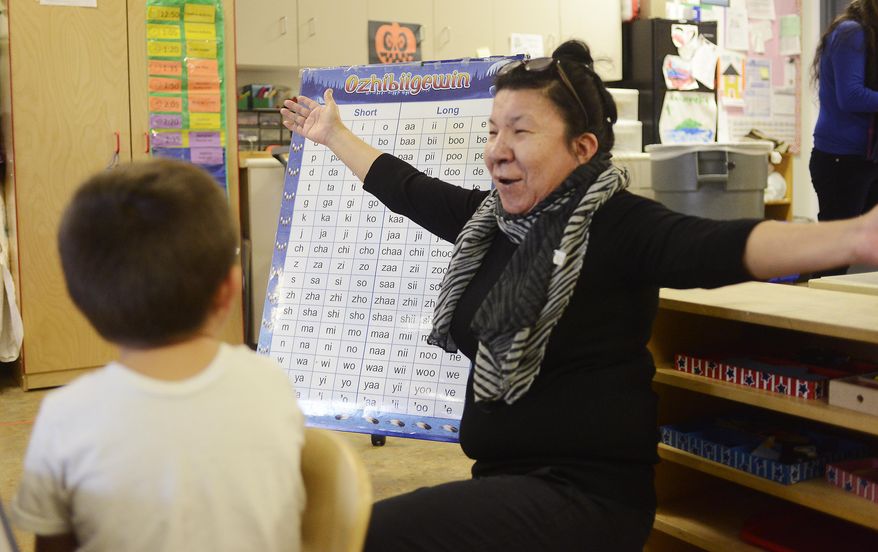 AVANCE USE SUNDAY, NOV. 30, AND THEREAFTER - In this photo taken on Nov. 13, 2014, teacher Carol Bob leads her classroom in the sound chart of the Anishinaabe language, the native language of the Saginaw Chippewa tribe, at the Sasiwaans Immersion Preschool in Mount Pleasant, Mich. The tribe is undertaking efforts to revitalize their native language through the Anishinabe Language Revitalization Department to help more tribal members be fluent speakers. (AP Photo/The State Journal, Dave Wasinger) NO SALES