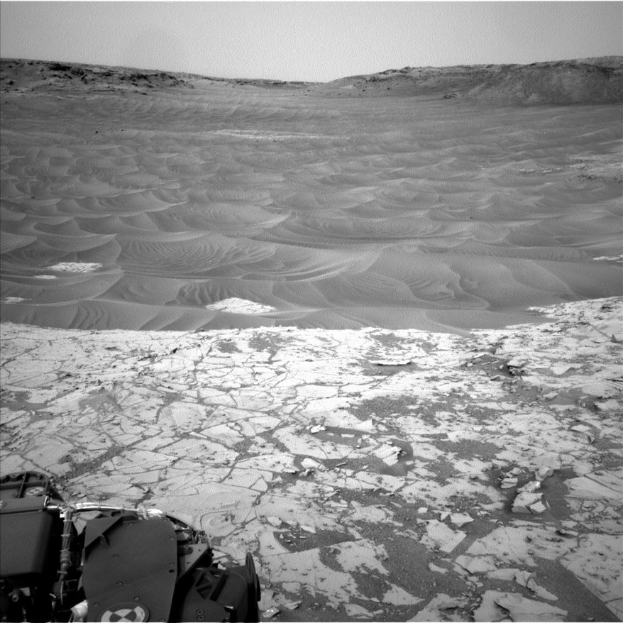 This photo taken Nov. 13, 2014, provided by the Jet Propulsion Laboratory and NASA and taken by the Curiosity Rover on the surface of Mars, shows the lower edge of the pale Pahrump Hills outcrop at the base of Mount Sharp includes wind-sculpted ripples of sand and dust in the middle ground. Some of the most innovative and challenging scientific research in human history is now underway in the Pahrump Hills, but not the ones 60 miles west of Las Vegas. These Pahrump Hills are down the highway another 55 million miles or so, at the base of a mountain in the bottom of a crater on the planet Mars. (AP Photo/JPL-NASA)