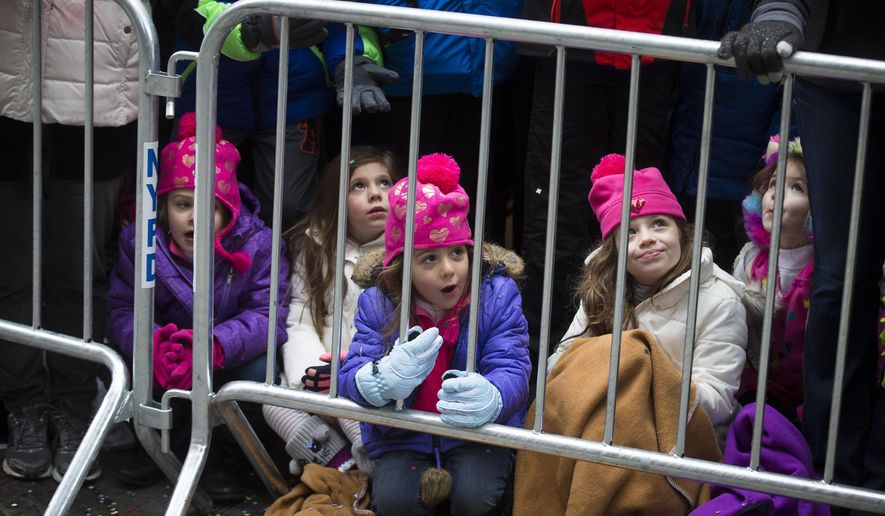 Olivia Piloto, center, watches from the barricades during the Macy's Thanksgiving Day Parade, Thursday, Nov. 27, 2014, in New York. (AP Photo/John Minchillo)