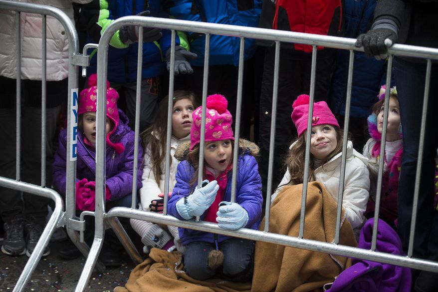 Olivia Piloto, center, watches from the barricades during the Macy's Thanksgiving Day Parade, Thursday, Nov. 27, 2014, in New York. (AP Photo/John Minchillo)