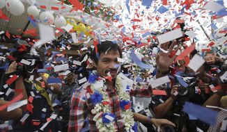 Filipino boxing hero Manny Pacquiao waves as confetti falls during a heroes welcome at the financial district of Makati, south of Manila, Philippines on Thursday Nov. 27, 2014. Pacquiao recently defeated Chris Algieri of the United States to win the WBO world welterweight title. (AP Photo/Aaron Favila)