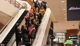 Protesters of the grand jury decision in the Michael Brown shooting chant slogans at the St. Louis Galleria mall on Wednesday evening, Nov. 26, 2014, in Richmond Heights, Mo. They stayed in the mall for about 15 minutes and then left peacefully without confrontation with a large police presence. (AP Photo/St. Louis Post-Dispatch, J.B. Forbres)