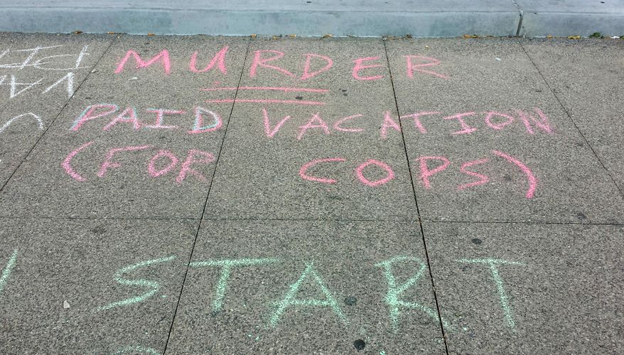 This Thursday, Nov. 27, 2014 photo shows one of many protest messages written in sidewalk chalk outside the Regional Justice Center in Las Vegas. Members of the group Sunset Activist Collective, some of whom were arrested in a similar protest last year, said they want more accountability for police involved in shootings. (AP Photo/Michelle Rindels)