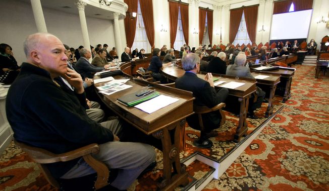Sen. Joe Benning, left, R-Caledonia, listens during a legislative gathering at the Statehouse on Wednesday, Nov. 20, 2013 in Montpelier, Vt. Growing numbers of pre-trial detainees in Vermont prisons and paying sheriffs to monitor mentally ill patients in hospital emergency rooms are among the many budget pressures facing Vermont state government. The administration of Gov. Peter Shumlin briefed lawmakers on the budget challenges they're expected to face when they return in January.(AP Photo/Toby Talbot)