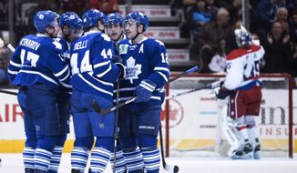 Toronto Maple Leafs&#39; Morgan Rielly (44) celebrates with teammates Leo Komarov (47) Nazem Kadri (43) Mike Santorelli (25) Stephane Robidas (12) in front of Washington Capitals goaltender Justin Peters after scoring a goal during the first period of an NHL hockey game, Saturday, Nov. 29, 2014 2014 in Toronto. (AP Photo/Canadian Press, Darren Calabrese)