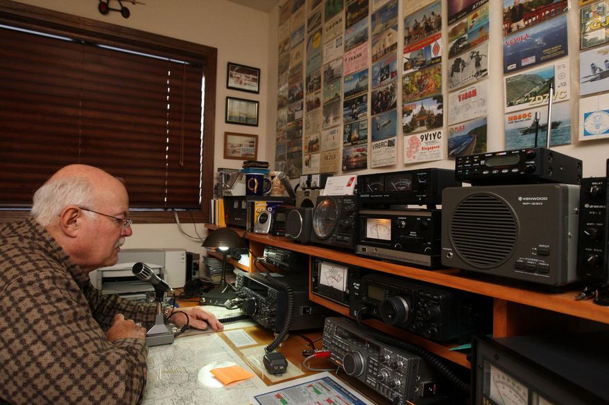 FOR RELEASE SATURDAY, NOVEMBER 29, 2014, AT 12:01 A.M. CST.- Sam Burrell makes a call on his ham radio in the room set up for his hobby Monday Nov. 17, 2014 at his home north of Burlington, Iowa. Burrell got hooked on the radio hobby in 1955 at the age of 14. The post cards on the wall are from some of the unique people his contacted including the International Space Station. (AP Photo/The Hawk Eye, John Gaines)