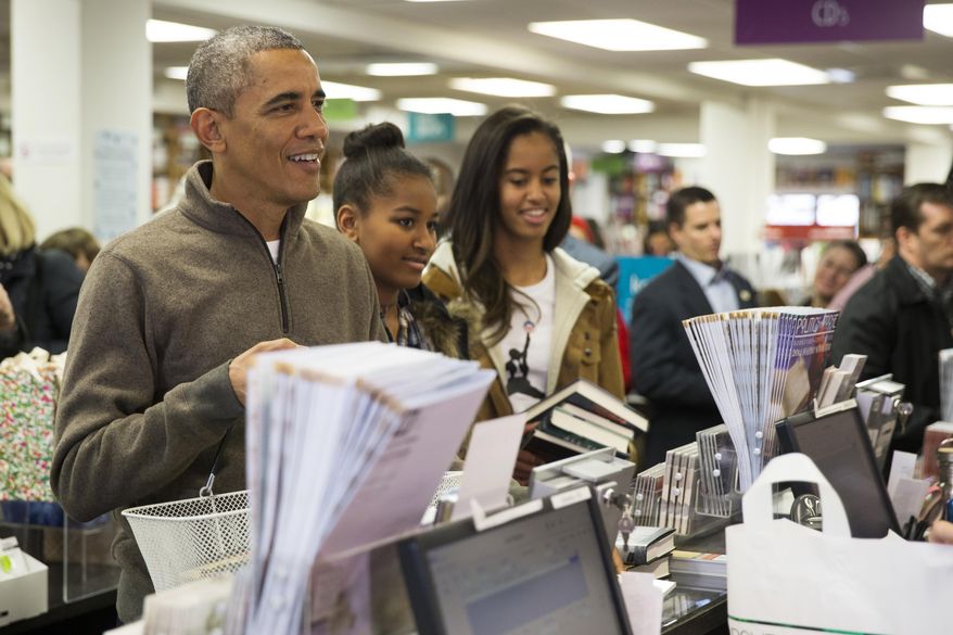 President Barack Obama, left, shops with his daughters, Sasha, center, and Malia, at Politics and Prose bookstore for "Small Business Saturday," on Saturday, Nov. 29, 2014, in Washington. (AP Photo/Evan Vucci)